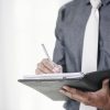 Close-up image of businessman signing contracts in folder